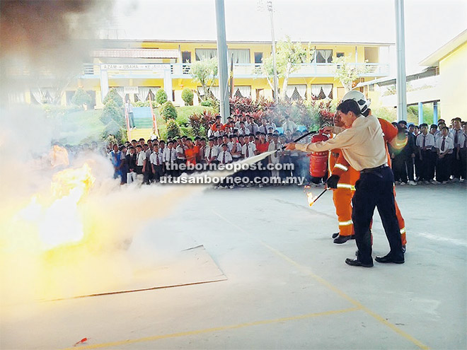  Demonstrasi memadam api dengan menggunakan alat pemadam api jenis serbuk melibatkan penyertaan warga sekolah sambil dipantau oleh anggota bomba.