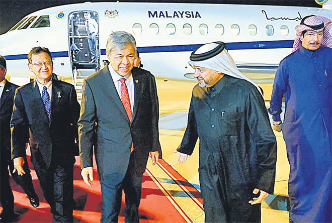  Ahmad Zahid disambut Pengarah Jabatan Hubungan Antarabangsa Qatar, Mejar Jen Abdulaziz A Alansari (dua, kanan) setibanya di Lapangan Terbang Antarabangsa Hamad sempena Lawatan Kerja semalam. Turut hadir Ahmad Jazri (kiri). — Gambar Bernama