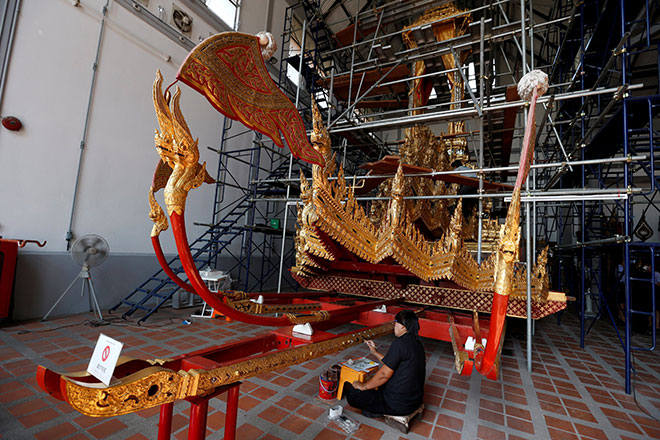  Para pegawai dari Bahagian Sains Pemuliharaan Jabatan Seni Halus Muzium Negara Thailand membaik pulih kereta kuda diraja menjelang pemakaman Bhumibol lewat tahun ini di Bangkok, kelmarin. — Gambar Reuters