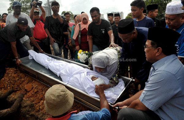  Anggota keluarga terdekat menatap buat kali terakhir jenazah Muhammad Firdauz Danish M.Azahar,16, sebelum dikebumikan di Tanah Perkuburan Islam Kebun Teh, Johor Bahru.  — Gambar Bernama