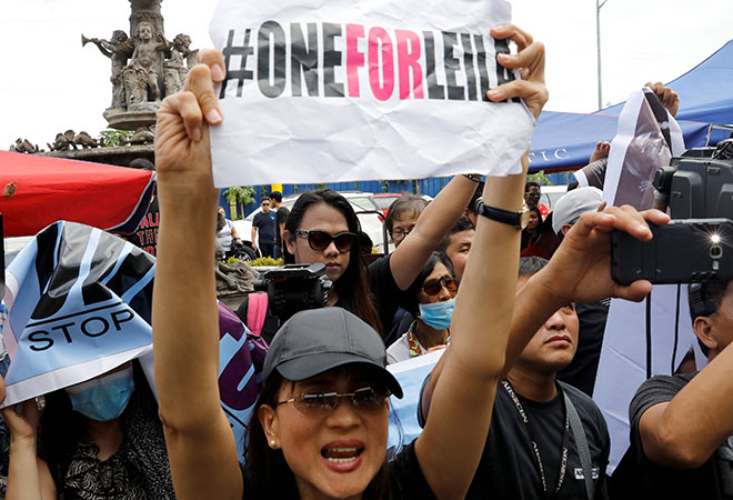  Penyokong Senator Filipina Leila De Lima mempamer plakad ketika menyertai perhimpunan di luar sebuah mahkamah di Muntinlupa, Metro Manila, semalam. — Gambar Reuters