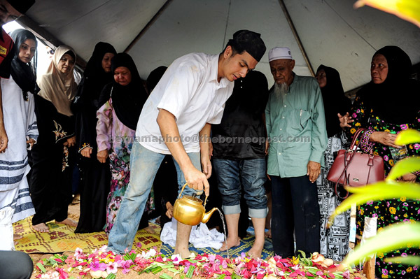  Anak Allahyarham Tan Sri Jins Shamsudin, Putera Hang Nadim menyiram air mawar ke atas pusara bapanya. — Gambar Bernama