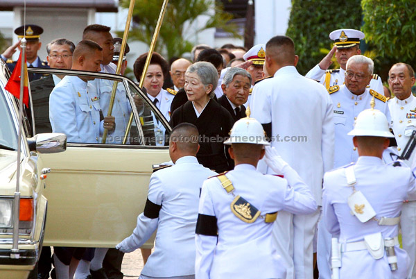  Akihito dan Michiko (tengah) tiba di Balai Singgahsana Istana Agung untuk memberi penghormatan kepada mendiang Bhumibol di Bangkok, kelmarin. — Gambar Reuters