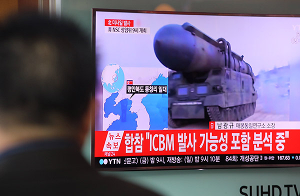  Laporan berita di televisyen yang menunjukkan rakaman arkib pelancaran misil Korea Utara disiarkan pada skrin awam di Seoul, semalam. — Gambar AFP