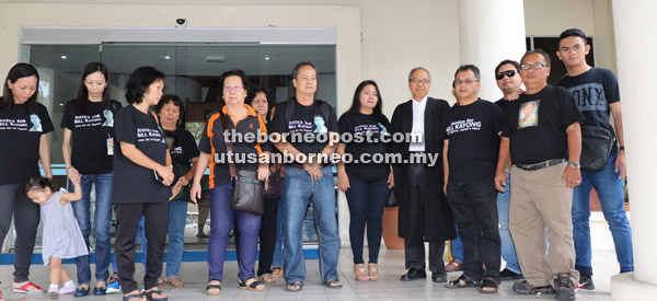  Hasyikin (enam kanan) dan ahli keluarga bergambar bersama Majen (memakai kot) selepas sesi perbicaraan tengah hari semalam.