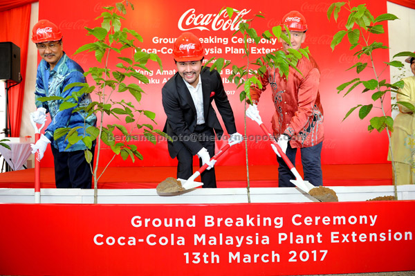  Tunku Ali Redhauddin (tengah) menanam pokok sempena Majlis Pecah Tanah Pembesaran Kilang Coca-Cola Malaysia di Bandar Enstek, dekat Nilai, semalam. — Gambar Bernama