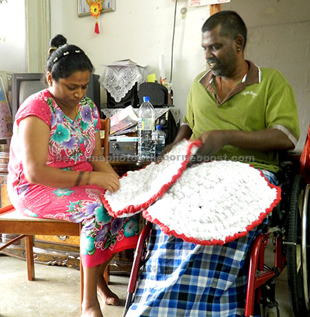  Jaya Letchumy Rasalingam, dan suaminya, Mageswaran Veerapan, masing-masing 41 tahun, memperkemaskan alas kaki yang siap dijahit. — Gambar Bernama