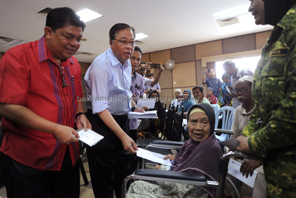  Ismail Sabri (dua kiri) menyampaikan baucar Bantuan Rakyat 1Malaysia (BR1M) kepada warga emas Jamaiah Tamin, 86, seorang daripada penerima BR1M Parlimen Bera di Bera, semalam. — Gambar Bernama