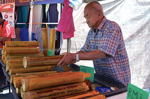  Ahmad Saad menyusun tabung buluh yang dibuat sendiri untuk dijual di Pasar Karat Kampung Berjaya. Tabung buluh yang dibuat 100 peratus buatan tangan itu boleh didapati dalam saiz XS hingga XXXL dengan harga semurah RM3 hingga RM15. — Gambar Bernama