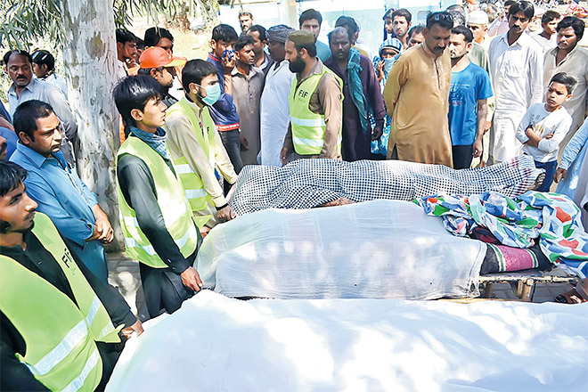  Sukarelawan menunggu ambulans untuk membawa mayat mangsa yang dibunuh di sebuah makam Su di pinggir daerah Sargodha dalam wilayah Punjab, semalam. — Gambar AFP