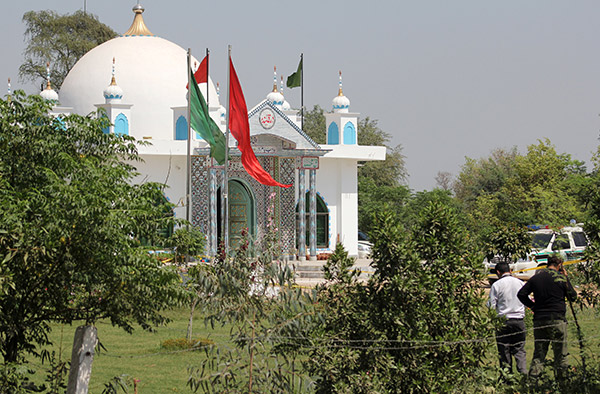  Anggota polis unit forensik (kanan) meninjau keadaan selepas kejadian tersebut di luar makam Sufi Mohammad Ali di pinggir Sargodha, kelmarin. — Gambar Reuters