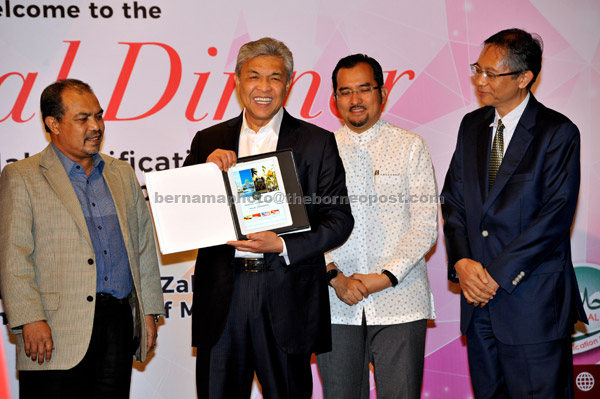  Ahmad Zahid menunjukkan ‘Ebook MABIMS’ yang diterima daripada Acting Director of the IDB Regional Office, Kunrat Wirasubrata (kanan) pada Konvensyen Badan Pensijilan Halal Ke-8 di Sepang kelmarin. Turut hadir Menteri di Jabatan Perdana Menteri Datuk Seri Jamil Khir Baharom (kiri) dan Timbalan Menteri di Jabatan Perdana Menteri Datuk Dr Asyraf Wajdi Dasuki (dua kanan). — Gambar Bernama