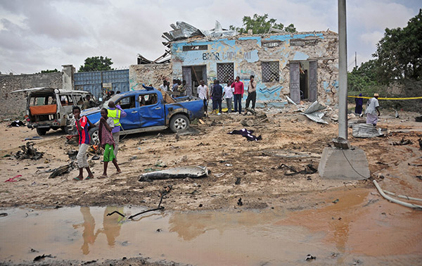  Orang ramai meninjau keadaan di sekitar tempat kejadian serangan bom kereta berhampiran ibu pejabat Kementerian Pertahanan di Mogadishu, kelmarin. — Gambar AFP