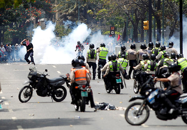  Penunjuk perasaan bertempur dengan polis rusuhan ketika perhimpunan menentang kerajaan Maduro di Caracas, Venezuela, Isnin lepas. — Gambar Reuters