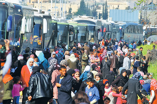  Penduduk yang dipindahkan dari dua bandar Kafraya dan Fuaa berhimpun berdekatan bas-bas yang ditangguhkan perjalanannya di Rashidin, wilayah Aleppo kelmarin manakala gambar kanan menunjukkan asap hitam berkepul susulan serangan bom van menyasari bas-bas itu. — Gambar Reuters/AFP