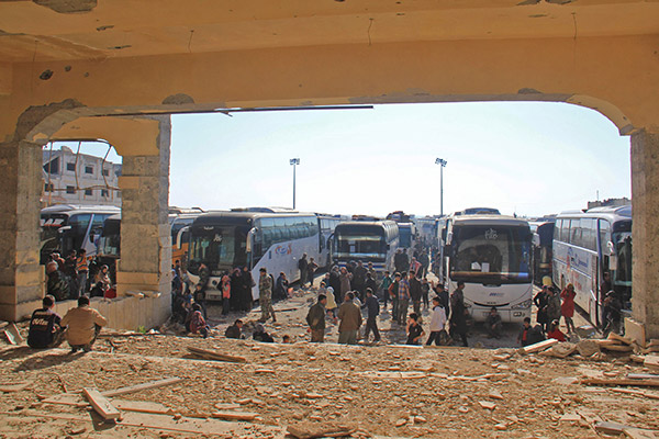  Orang awam dan pemberontak dari bandar Fuaa dan Kafraya tiba dengan bas di pinggir Rashidin luar Aleppo semalam. — Gambar AFP