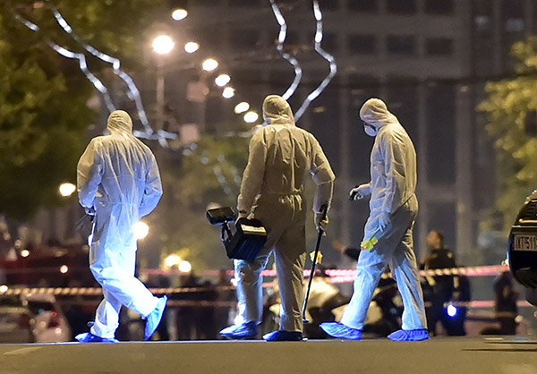  Pegawai forensik memeriksa bukti selepas serangan bom merosakkan cawangan bank Greek, Eurobank, di tengah Athens, kelmarin. — Gambar AFP