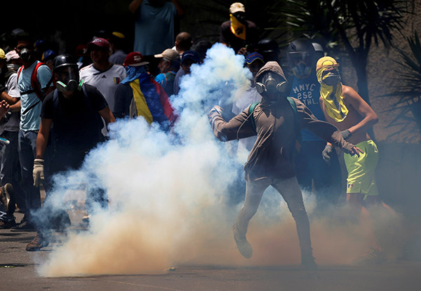  Penunjuk perasaan bertempur dengan polis rusuhan ketika menyertai ‘perarakan terbesar’ menentang pemerintahan Maduro di Caracas, Venezuela, kelmarin. — Gambar Reuters