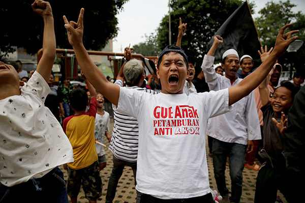  Penyokong calon Gabenor Jakarta Anies Baswedan bersorak gembira ketika Baswedan mendahului dalam kiraan undi di pusat mengundi Petamburan di Jakarta, Indonesia kelmarin. — Gambar Reuters