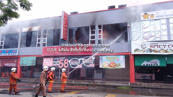  Anggota bomba berusaha memadam kebakaran tiga unit tingkat atas bangunan kedai tersebut.