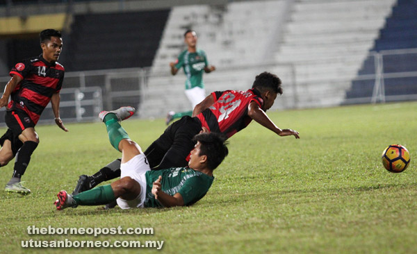  Penyerang Kuching FA, Sufizal Ismail (hijau) mengasak pertahanan Terengganu City FC, Muhd Zulhairi Ismail pada perlawanan Piala FAM kelmarin.