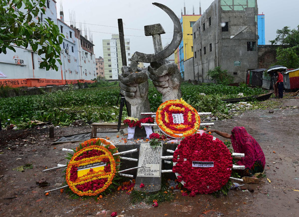  Seorang wanita yang kehilangan anaknya dalam runtuhan kompleks kilang Rana Plaza menangis berhampiran tugu peri-ngatan dekat tempat kejadian semasa demonstrasi ulang tahun keempat bencana itu di Savar, pinggir Dhaka semalam. — Gambar AFP