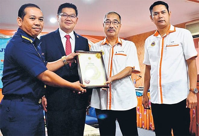 Kamarudin (tiga kiri) menyerahkan Anugerah Tokoh JPJ kepada Mohd Shaiful (kiri) selepas merasmikan Hari JPJ ke-71 peringkat negeri di Melaka, semalam. — Gambar Bernama