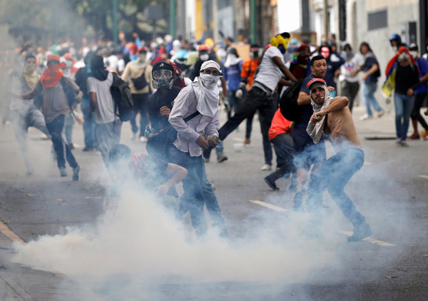  Penyokong pembangkang bertempur dengan pasukan keselamatan semasa perhimpunan anti-Maduro di Caracas, Venezuela kelmarin. — Gambar Reuters