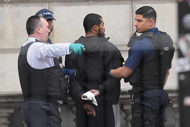  Polis menahan seorang lelaki di Westminster semasa serbuan antikeganasan di tengah London kelmarin. — Gambar Reuters