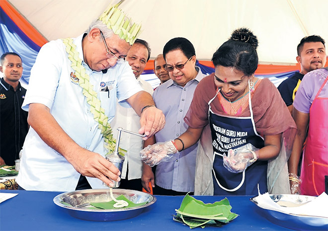  Mahdzir membantu membentuk adunan muruku ketika melawat ruang pameran sempena Program Guru Bersama Pemimpin dan Masyarakat Peringkat Negeri Sembilan di Sekolah Menengah Za’aba dekat Kuala Pilah, semalam. Turut kelihatan Pengerusi Jawatankuasa Bertindak Pendidikan dan Kesihatan negeri Datuk Shamsulkahar Mohd Deli (tengah). — Gambar Bernama