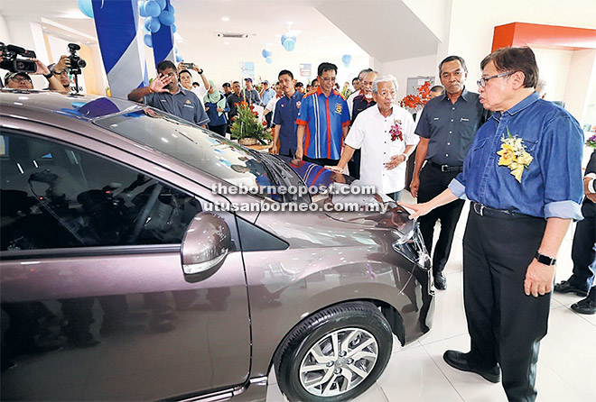  Abang Johari( kanan) beratika entukar (Perodua) ke dipandang ba MD World Sdn Bhd. bela dipeda (dua ari kanan) Zahari enggau Masing.