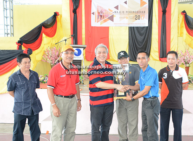  Awang Tengah (tiga kiri) menyerahkan piala pusingan kepada pasukan juara kontinjen PSKPP Daerah Lawas sambil disaksikan Ibrahim (dua kiri), Mohamad (empat kiri) dan Hussaini (kanan).