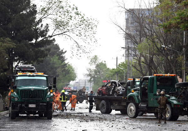  Kakitangan keselamatan menjalankan siasatan di tempat kejadian yang menyasari konvoi tentera asing dekat kedutaan AS di Kabul, semalam. — Gambar AFP