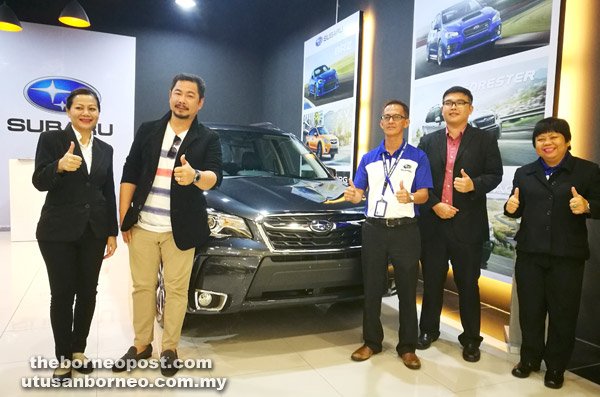  Ambrose (dua kiri) bersama penasihat jualan Sebangga Auto Sdn Bhd menunjukkan antara kereta Subaru yang dipamerkan di galeri pameran di Vivacity.