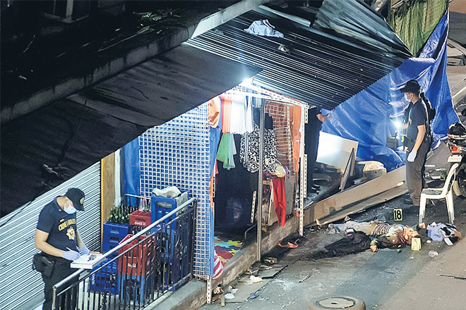  Mayat seorang mangsa bergelimpangan di tempat kejadian ketika para pegawai polis membuat siasatan di Quiapo, Manila kelmarin. — Gambar AFP