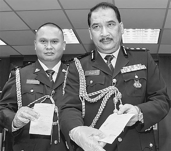  Mohd Salleh (tengah) menunjukkan sijil cuti palsu yang dirampas dalam tangkapan sindiket pemalsuan sijil cuti sakit di Ibu Pejabat Polis Kontinjen Johor, semalam. — Gambar Bernama