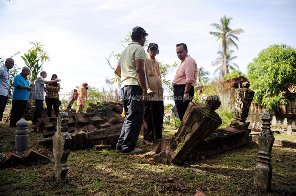  Wan Samsudin (dua, kanan) melihat salah sebuah makam dianggarkan berusia 239 tahun semalam. — Gambar Bernama