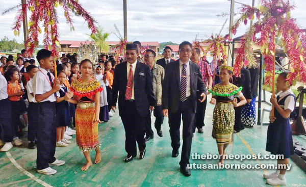  Janudin (kiri) bersama tetamu dan guru-guru lain mengiringi  John (kanan) ke dewan terbuka SK Tatau sempena meraikan persaraannya.