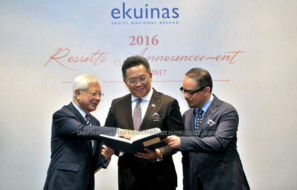  Abdul Rahman (tengah) melihat buku laporan tahunan Ekuiti Nasional Berhad (Ekuinas) 2016 pada majlis Pengumuman Keputusan Perolehan Ekuinas 2016 di Kuala Lumpur semalam. Turut kelihatan Raja Arshad (kiri) dan Syed Yasir Arafat. — Gambar Bernama