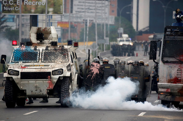  Pegawai polis antirusuhan bertempur dengan penyokong pembangkang semasa rali anti-Maduro di Caracas, kelmarin. — Gambar Reuters