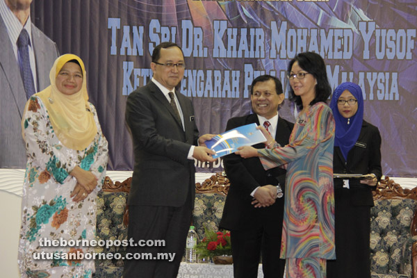  Amin (dua kiri) menyampaikan anugerah kepada salah seorang penerima. Turut kelihatan ialah Maimunah (kiri).