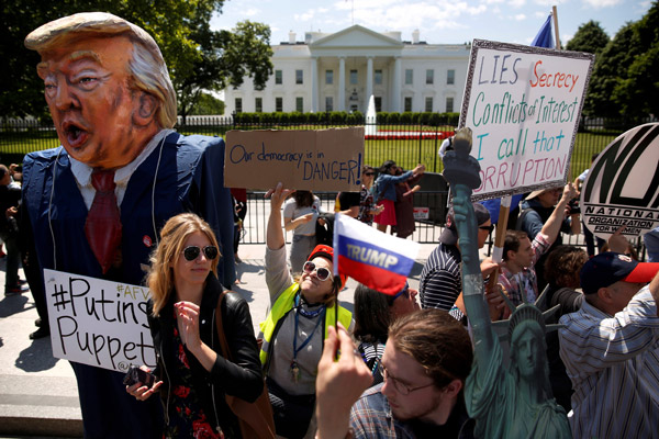  Penunjuk perasaan berhimpun untuk membantah tindakan Trump memecat pengarah FBI di luar pekarangan Rumah Putih di Washington, kelmarin. — Gambar Reuters