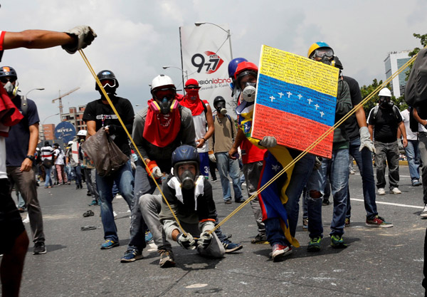  Penunjuk perasaan menggunakan lastik besar untuk membaling ‘koktel Poopootov’ – najis yang disimpan dalam botol kaca kecil, ketika menyertai perhimpunan menentang Maduro di Caracas, Venezuela, kelmarin. — Gambar Reuters
