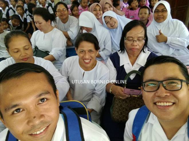 Moris (kiri depan) berswafoto bersama rakan warga pendidik yang lain ketika sambutan Hari Guru 2017 di SK Selampit, Lundu hari ini.