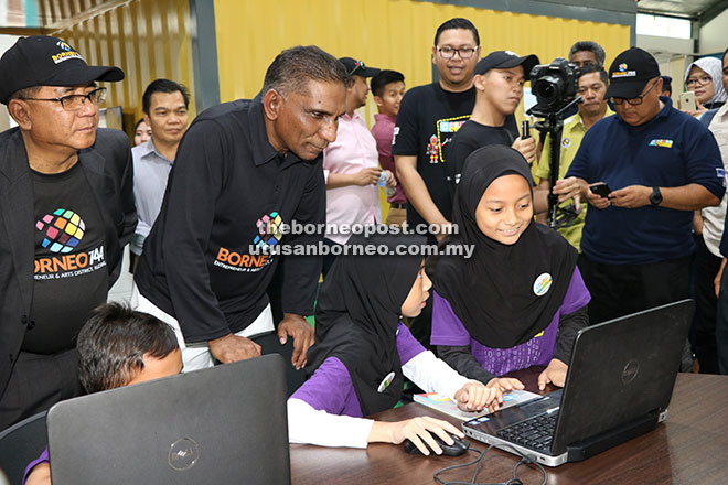  Irwan Serigar ditemani Jaul (kiri) melihat kecekapan pelajar sekolah rendah mencipta dan menulis kod perisian aplikasi sempena program Coding@Schools di Borneo 744, Bintawa semalam.