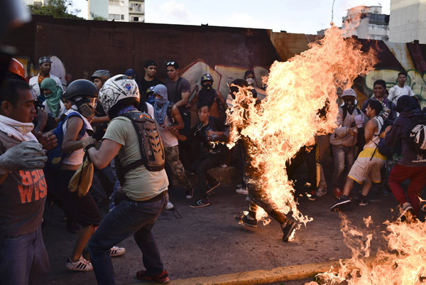  Penunjuk perasaan pembangkang membakar Figuera yang dituduh sebagai ‘Chavist’ atau pencuri semasa mengadakan protes anti-Maduro di Caracas, kelmarin. — Gambar AFP