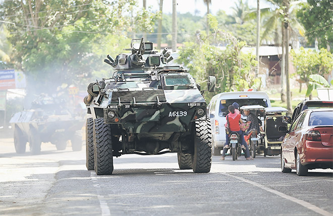  Sebuah kereta kebal membawa anggota tentera memasuki lebuh raya utama bandar Pantar, Lanao Del Norte dalam perjalanan untuk mengukuhkan keselamatan di Marawi, semalam. — Gambar Reuters