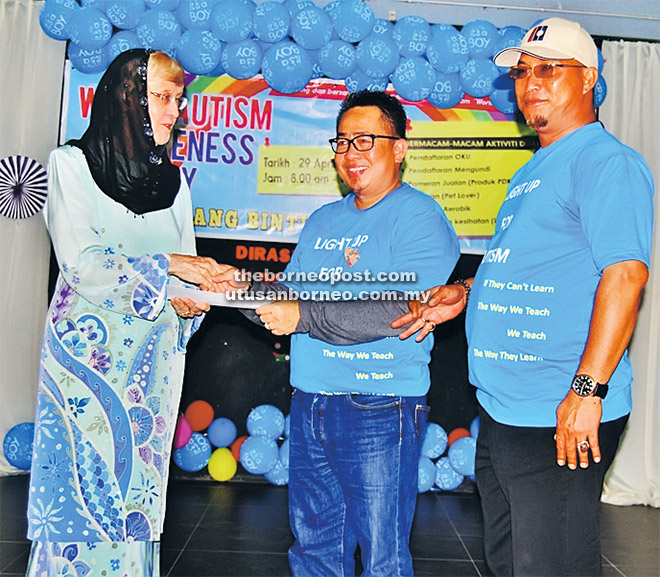  Dr Zaliha (kiri) menyampaikan sumbangan kepada Zephyan untuk PDK Gemilang sambil disaksikan oleh Wan Sulaiman (kanan).