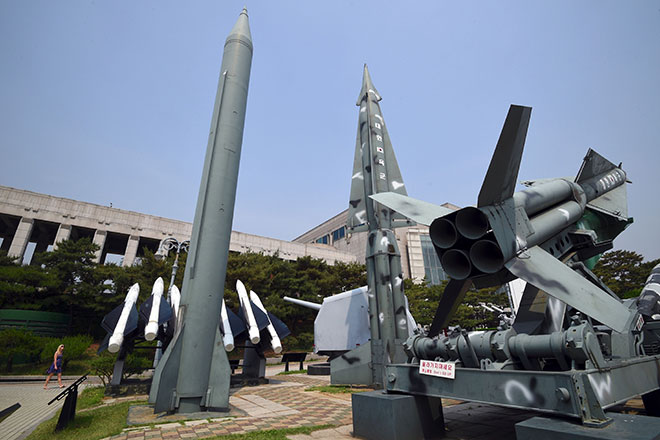  Seorang wanita melintasi replika misil Scud-B Korea Utara (kiri) dan misil Nike Korea Selatan (kanan) yang dipamerkan di Tugu Perang Korea di Seoul, semalam. — Gambar AFP