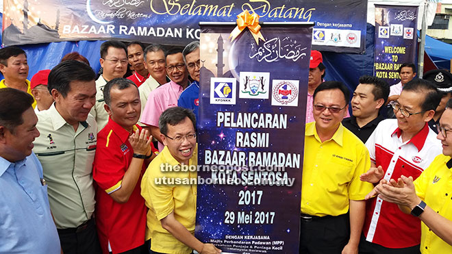  Dr Sim (empat kiri) selesai merasmikan Bazar Ramadan Kota Sentosa dalam kawasan MPP di Kuching semalam.                                       Turut kelihatan Lo (dua kanan) dan yang lain. 